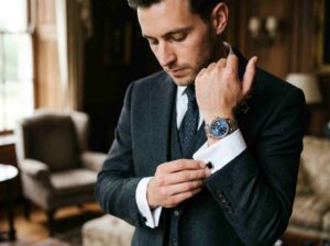 Close-up portrait of groom in wedding suit adjusting cufflinks